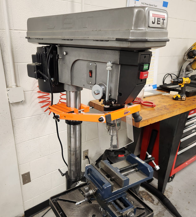 Drill press safety guarding installed in a workshop setting